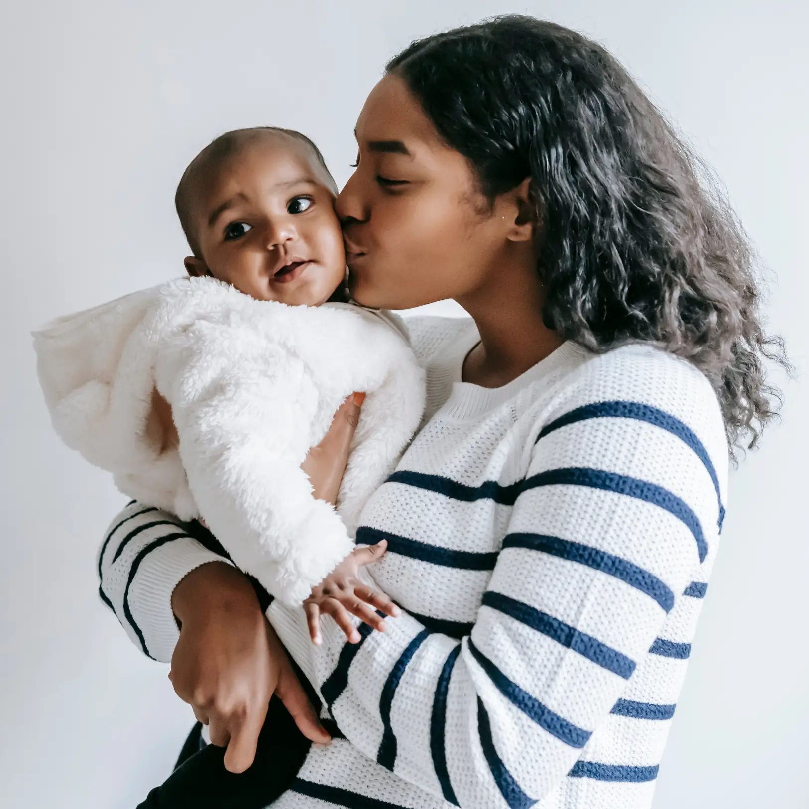 black mother lovingly kissing her baby's cheek
